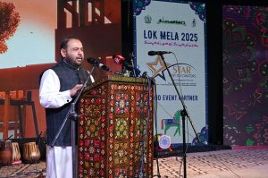 Federal Minister for National Heritage and Culture, Aurangzeb Khan Khichi, presenting a traditional shawl to a folk artist as a mark of respect during the inaugural ceremony of the ten-day annual folk festival “Lok Mela 2025” at Lok Virsa