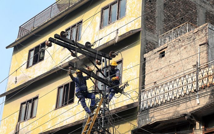 WAPDA electricians repair damaged electricity wires on a pole to restore power in the Banni area of the old city in twin cities