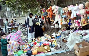 A family purchasing toys from roadside vendor.