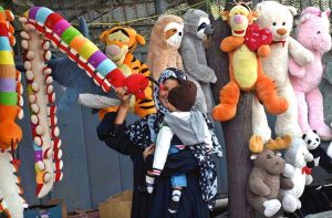 A family purchasing toys from roadside vendor.