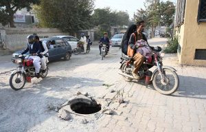 Girl crosses a canal using a temporarily laid electric pole at Shamsher Town