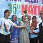 Khwaja Idrees, representing the Punjab Olympic Association, hands over the torch to athletes Vice Chancellor Dr. Uzma Qureshi and Dr. Sameera Sattarat during the 35th National Games torch relay ceremony at Lahore College for Women.