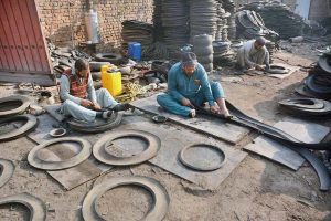 Workers busy in recycling work of disposed tires at their workplace near Ring road.