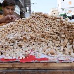 A vendor selling traditional sweet items at Jinnah Bagh Road