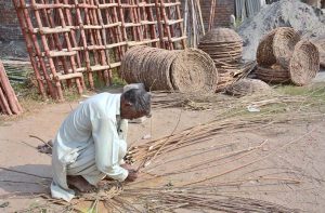 A skilled artisan crafting a wooden stick basket at his workplace.