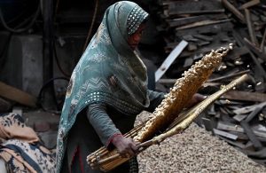 Female workers cleaning peanuts before supply to different markets at their workplace in the provincial capital.