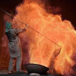 A worker prepares a traditional coal oven to steam corn at his workplace before it is sold to vendors in the provincial capital