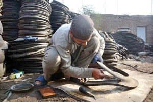 Workers busy in recycling work of disposed tires at their workplace near Ring road.