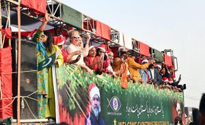 Foreigners wave to participants during the Welcome Christmas Rally