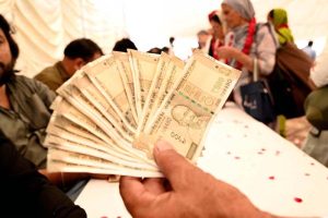 Indian Sikh pilgrims exchanging indian currency into Pakistani rupees after their arrival in Pakistan after crossing the India-Pakistan Wagah Border on the eve of celebrations marking the birth anniversary of Guru Nanak, the founder of Sikhism. Nearly two thousand Sikh pilgrims from India entered Pakistan in the first major crossing since deadly clashes in May led to the closure of the land border between the two neighbouring countries