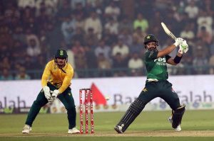 Pakistan’s batter Babar Azam raises his bat to acknowledge the crowd after completing his fifty during waving bat after completed fiffty during the third T20 international cricket match between Pakistan and South Africa at the Gaddafi Stadium.