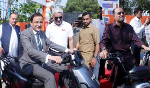 Chairman Water Corporation and Mayor Karachi, Mr. Murtaza Wahab, Deputy Mayor Karachi, Salman Abdullah Murad are seated on EV bikes at the inauguration of Karachi Water Corporation's first station suction machines and four electric vehicle charging stations at Sharaa Faisal Karsaz