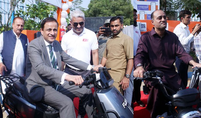 Chairman Water Corporation and Mayor Karachi, Mr. Murtaza Wahab, Deputy Mayor Karachi, Salman Abdullah Murad are seated on EV bikes at the inauguration of Karachi Water Corporation's first station suction machines and four electric vehicle charging stations at Sharaa Faisal Karsaz