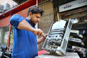 Mechanic busy in repairing instant geyser at his workplace near Khyber Bazar
