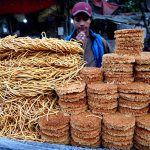 A street vendor displaying the traditional food items on their handcart to attract the customers on the roadside setup