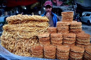 A street vendor displaying the traditional food items on their handcart to attract the customers on the roadside setup