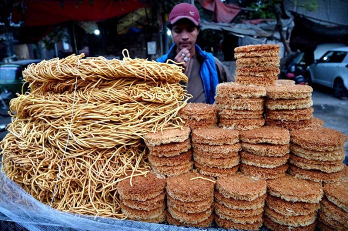 A street vendor displaying the traditional food items on their handcart to attract the customers on the roadside setup