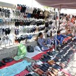 Vendor displaying used shoes to attract the customers at Old Bus Stand Road
