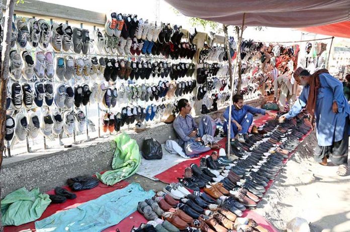 Vendor displaying used shoes to attract the customers at Old Bus Stand Road