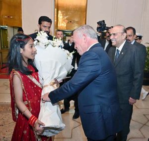 A bouquet being presented to His Majesty King Abdullah II ibn Al Hussein of the Hashemite Kingdom of Jordan upon his arrival at Aiwan-e-Sadr.