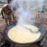 A farmer preparing gur (jaggery) in a traditional way from sugarcane juice at his farm
