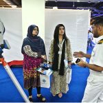 A naval officer briefing female visitors at a stall established during the 2nd Edition of Pakistan International Maritime Expo and Conference 2025 at Expo Centre