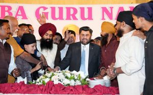 Sindh Governor Kamran Khan Tessori cutting a cake along with participants to celebrate the 556th birth anniversary of Baba Guru Nanak, the spiritual leader of the Sikh community, at the Governor House
