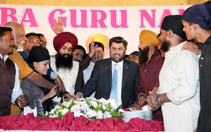 Sindh Governor Kamran Khan Tessori cutting a cake along with participants to celebrate the 556th birth anniversary of Baba Guru Nanak, the spiritual leader of the Sikh community, at the Governor House