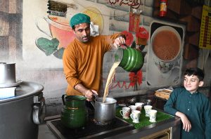 A tea vendor prepares a fresh cup at his shop along Multan Road.