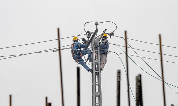 WAPDA workers installing new electrical wires at Kacheri Chowk