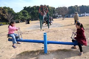 Children enjoy seesaw in F-9 Park during their winter vacation.
