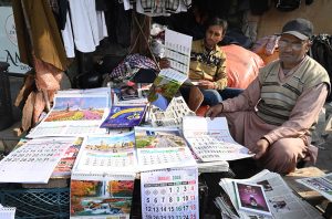 A local newsagent offers New Year 2026 calendars at Anarkali Chowk.