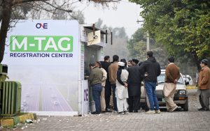 A long queue of commuters waiting for their turn to get M-TAG from a registration center in Kachnar Park in sector I-8.
