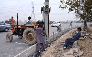 Labourers are busy installing a protection wall along the Faizabad Interchange in the Federal Capital.