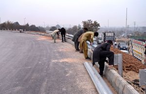 Labourers are busy installing a protection wall along the Faizabad Interchange in the Federal Capital.