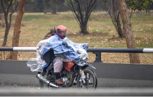 A pedestrian takes shelter under an umbrella walks along the roadside during downpour experienced in the city.