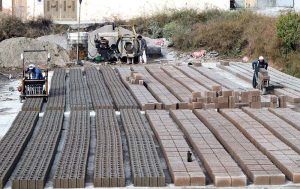 Workers are busy preparing cemented blocks at their workplace