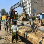 Labourers carry out sewerage pipeline construction using heavy machinery in Latifabad as part of ongoing development work.