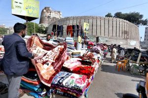 A vendor displaying blanket to a customer at Bacha Khan Chowk.