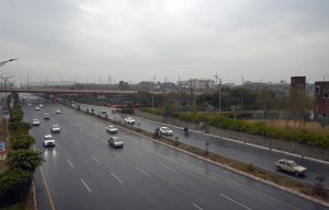 A scenic view of vehicles passing along Srinagar Highway under clouds hovering over the sky after rain in the Federal Capital.