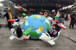 Children enjoy a swing during a fun fair for journalists’ families at Chacha Younas Park, arranged by the Press Club