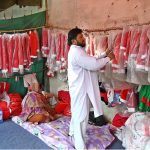 A vendor is arranging and displaying Santa Claus dresses in connection with the upcoming Christmas celebrations at a stall in the G-7 area of the Federal Capital