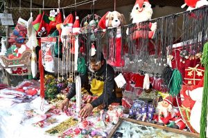 A vendor is arranging and displaying Santa Claus dresses in connection with the upcoming Christmas celebrations at a stall in the G-7 area of the Federal Capital