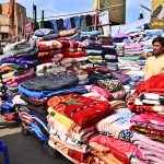 A vendor displaying blanket to attract the customer at Bacha Khan Chowk.