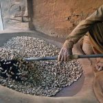 A worker busy roasting peanuts at his workplace in a local market
