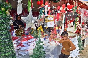 A vendor is arranging and displaying Santa Claus dresses in connection with the upcoming Christmas celebrations at a stall in the G-7 area of the Federal Capital