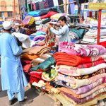 A vendor displaying the used blankets to attract the customers during winter season at Bacha khan chowk.