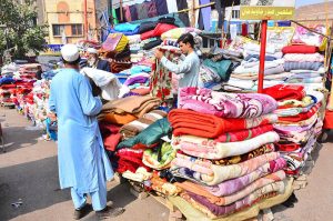 A vendor displaying the used blankets to attract the customers during winter season at Bacha khan chowk.