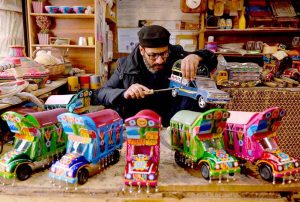 A skilled artisan applies the finishing touches to a handcrafted van model at his workshop located near Namak Mandi Chowk.