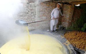 An elderly man prepares traditional sweet gur from sugarcane juice in Tang Koruna, Charsadda.
